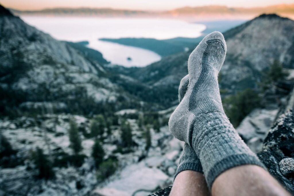 hombre con calcetines de trekking en la montaña