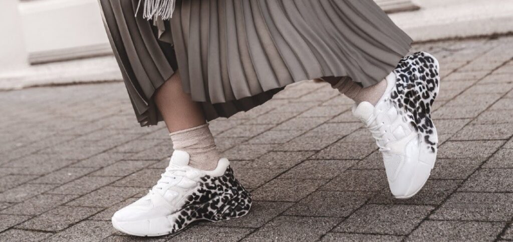 mujer con vestido largo y zapatillas blancas