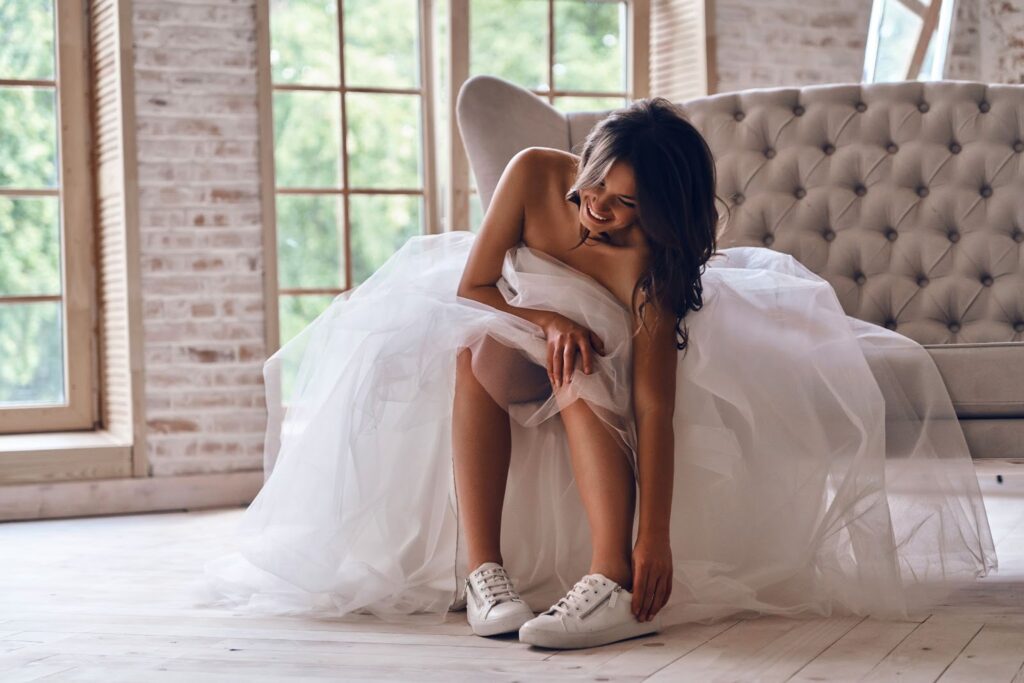 Mujer en vestido de novia y zapatillas blancas